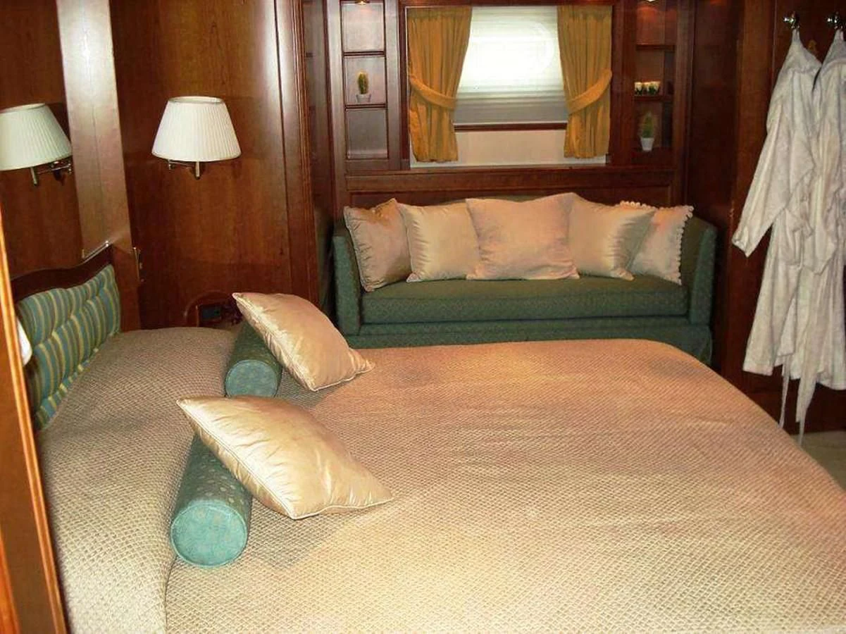 a bed with a green bed spread aboard LADY ANN Yacht for Sale