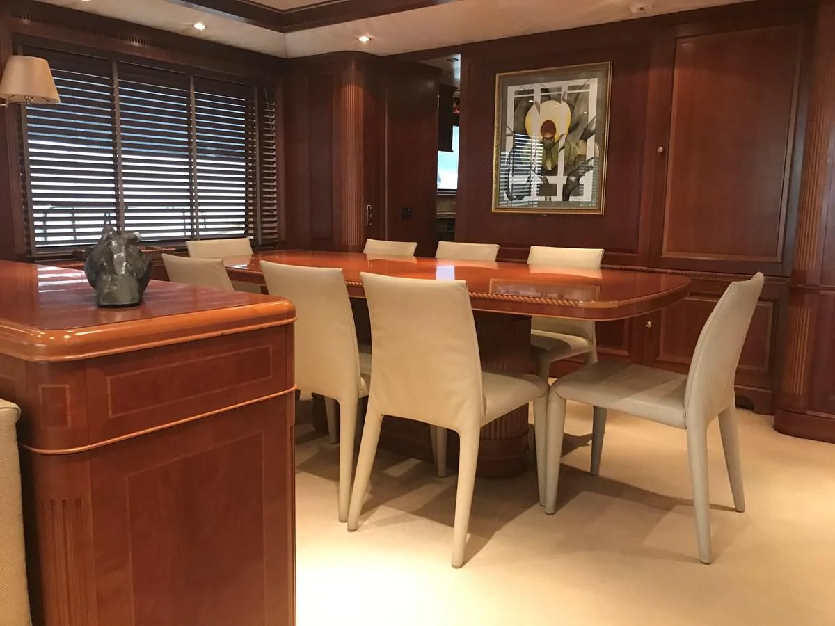 a room with a table chairs and a piano aboard LADY ANN Yacht for Sale