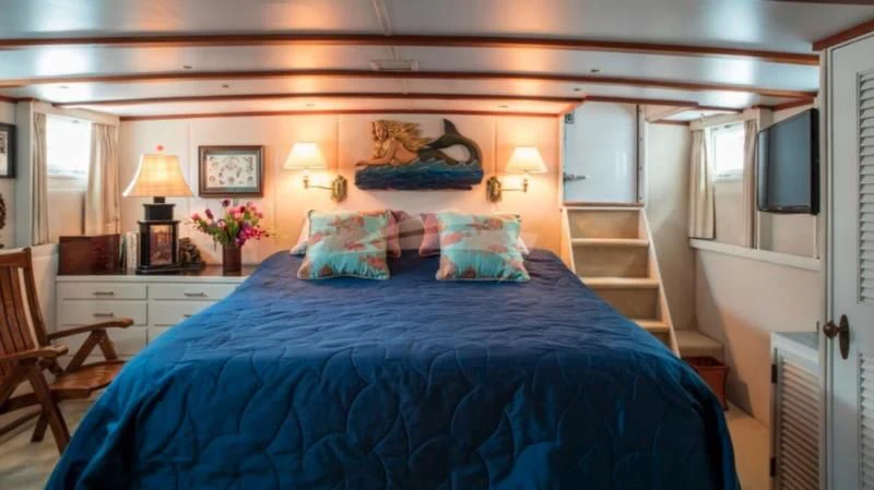 a bed with blue sheets aboard SEAFARI Yacht for Sale