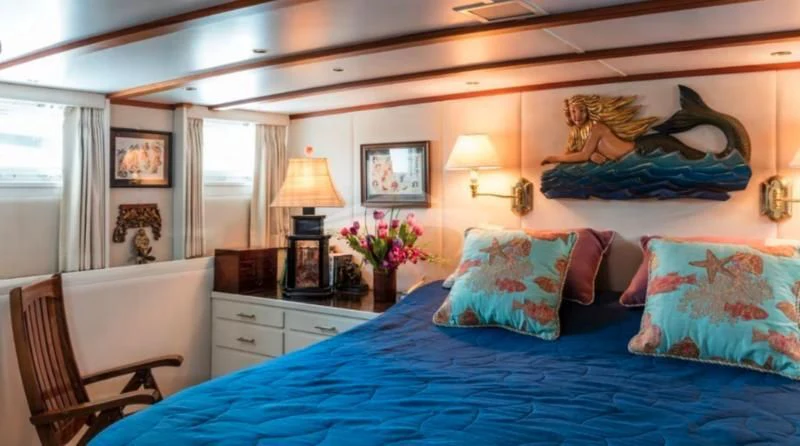 a bedroom with a bed and a lamp aboard SEAFARI Yacht for Sale