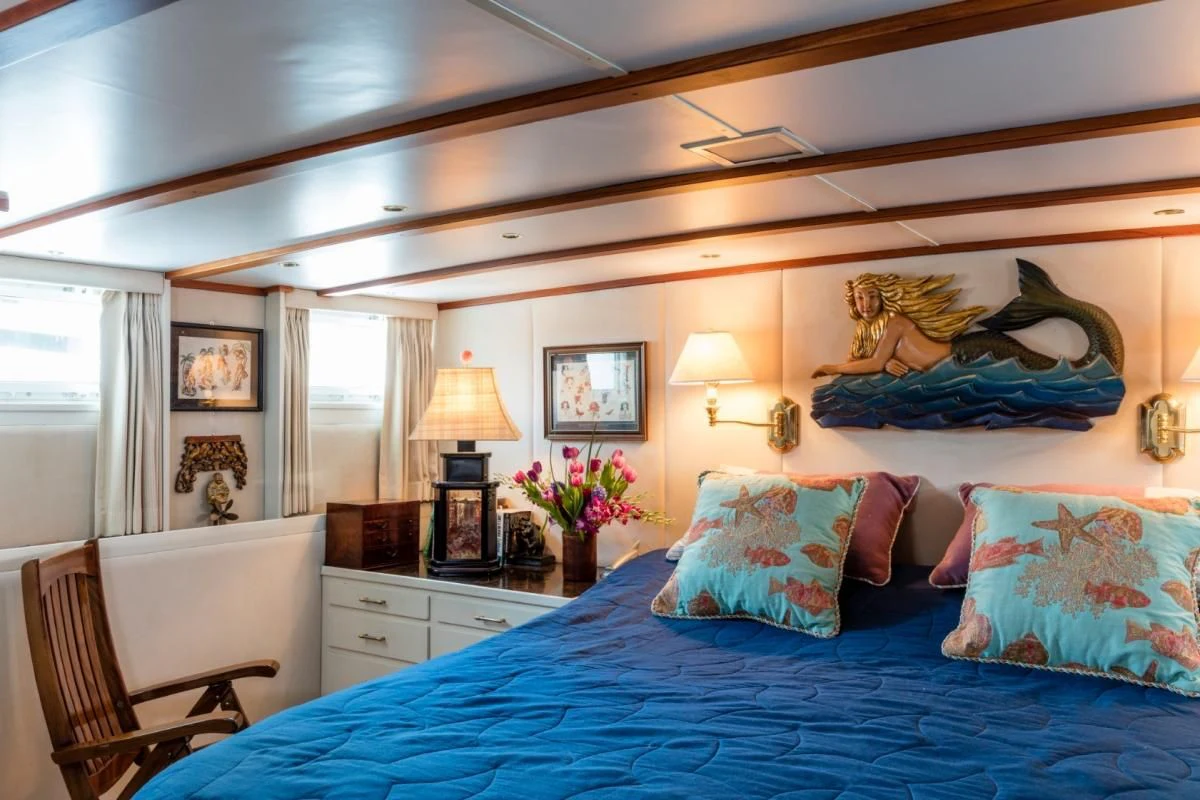 a bedroom with a bed and a lamp aboard SEAFARI Yacht for Sale
