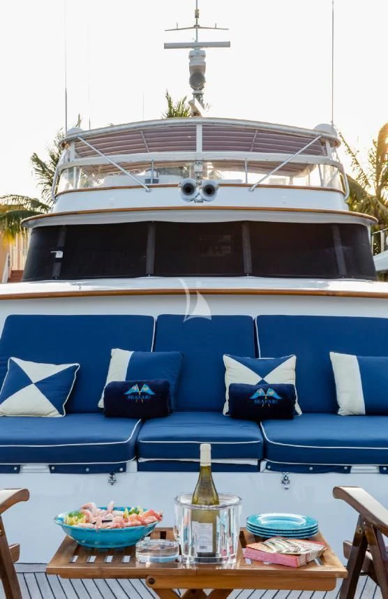 a blue couch and a table with a glass bottle and a white gazebo with a white sky aboard SEAFARI Yacht for Sale