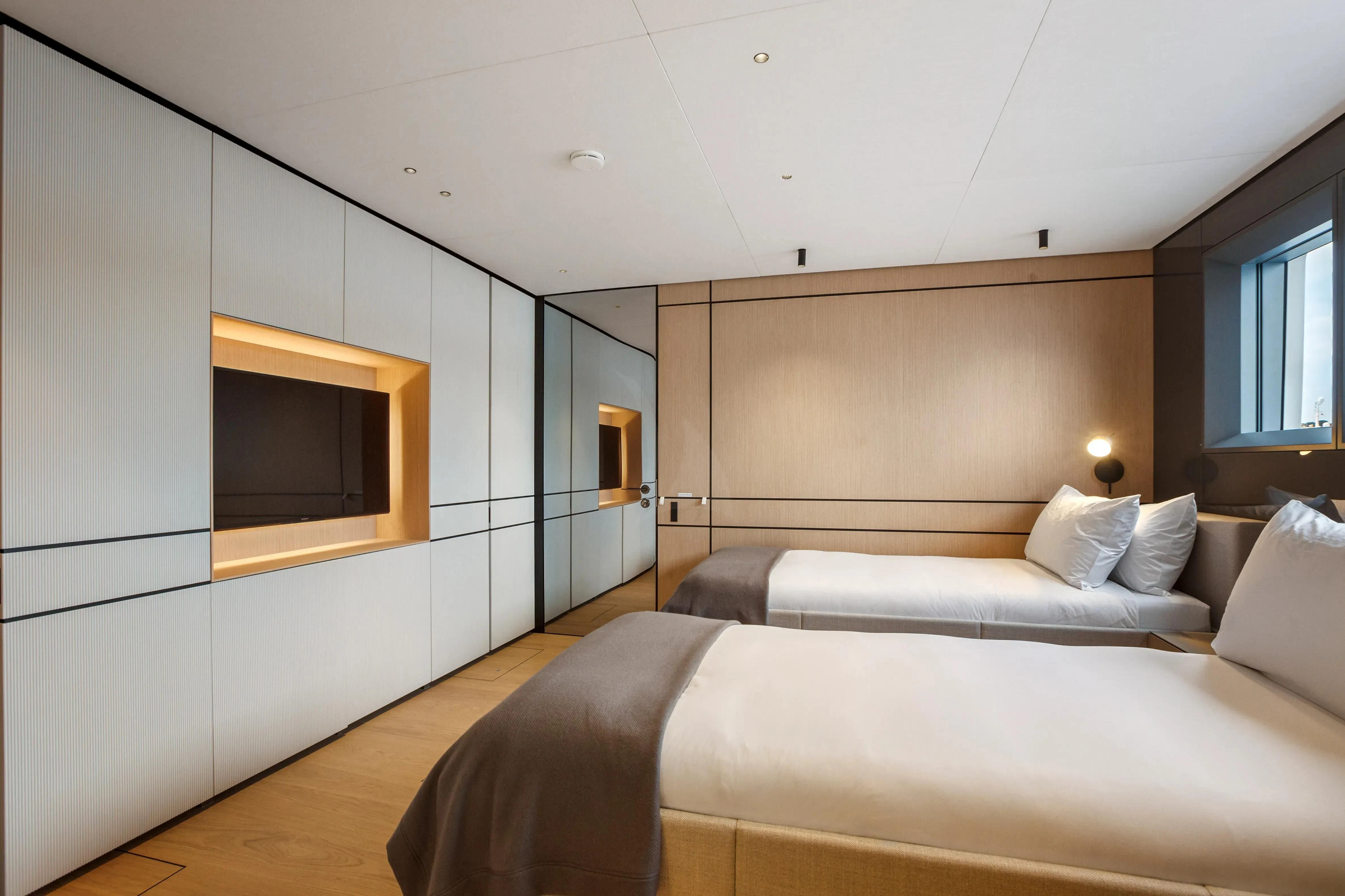 a bedroom with a bed and a tv on the wall aboard EXTRA TIME Yacht for Sale