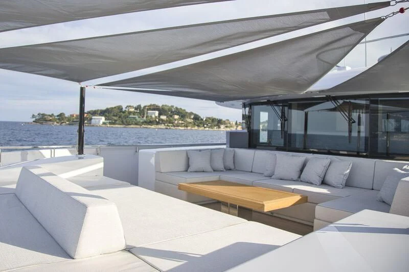a modern living room with a large balcony overlooking the ocean aboard EXTRA TIME Yacht for Sale