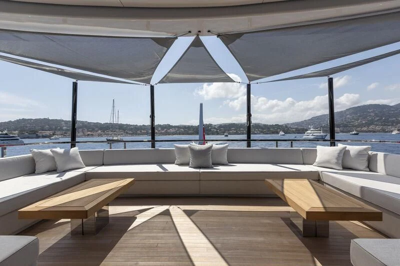 a room with a couch and a table with chairs on it aboard EXTRA TIME Yacht for Sale