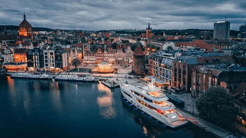 a city with boats and buildings along the water aboard EXTRA TIME Yacht for Sale