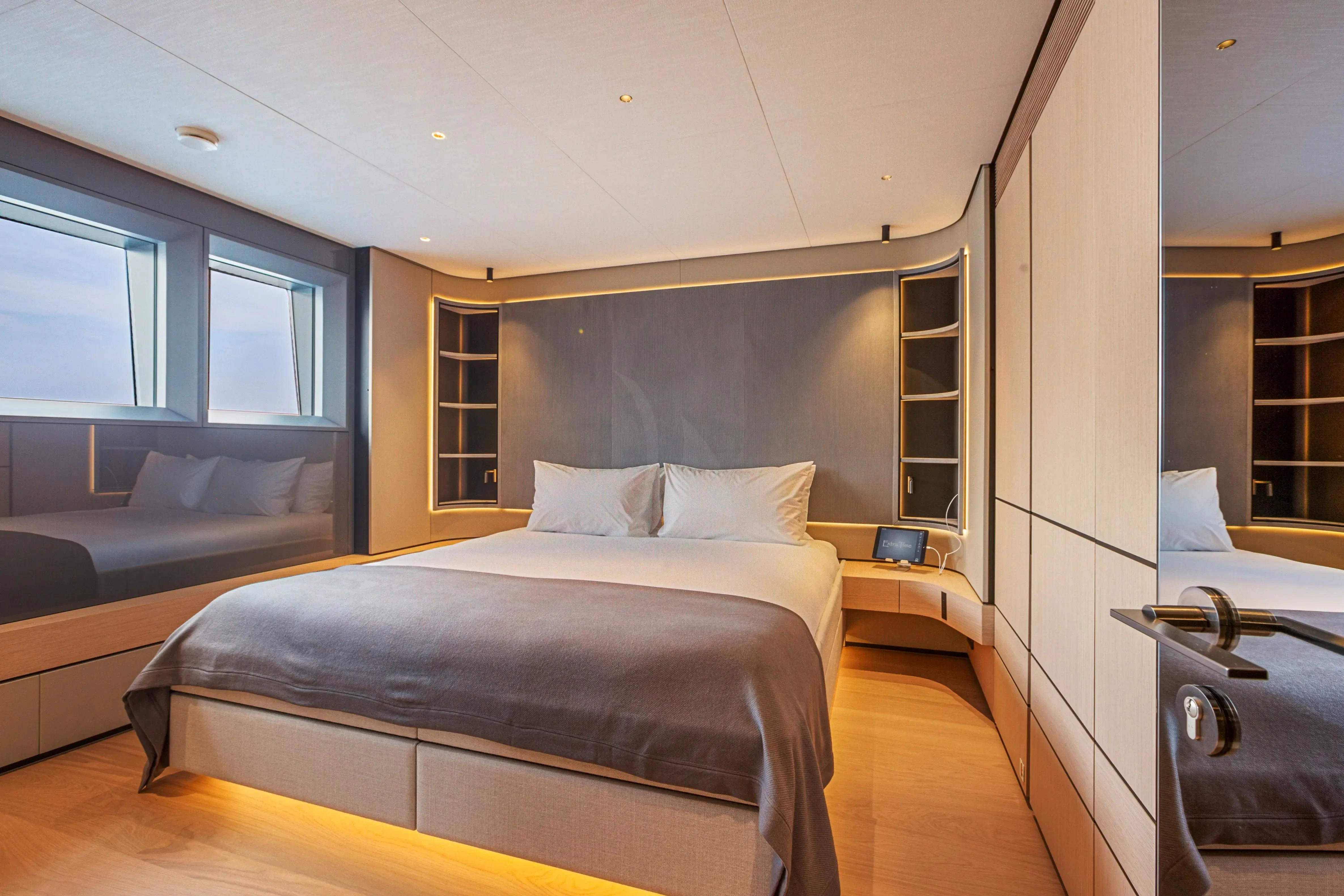 a bedroom with a bed and a couch aboard EXTRA TIME Yacht for Sale