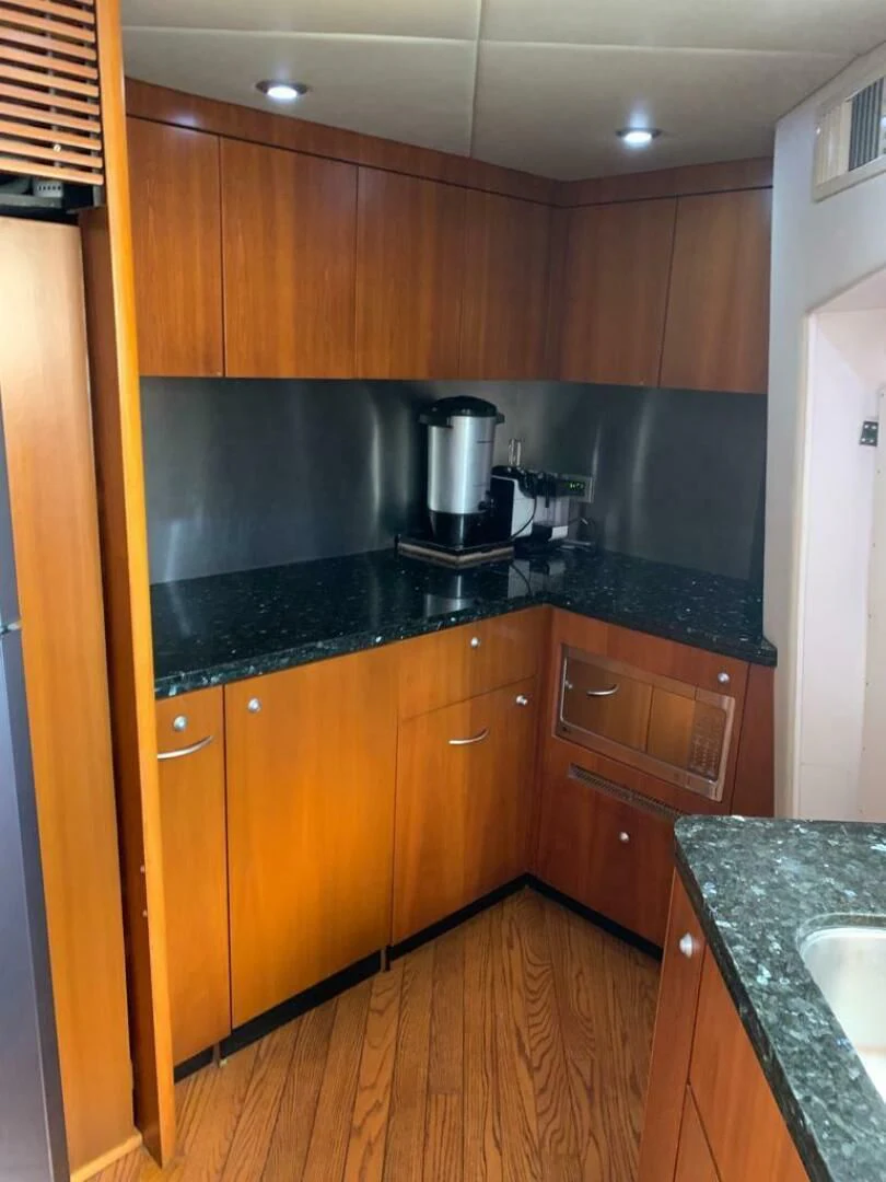 a kitchen with wooden cabinets aboard JULCAN II Yacht for Sale