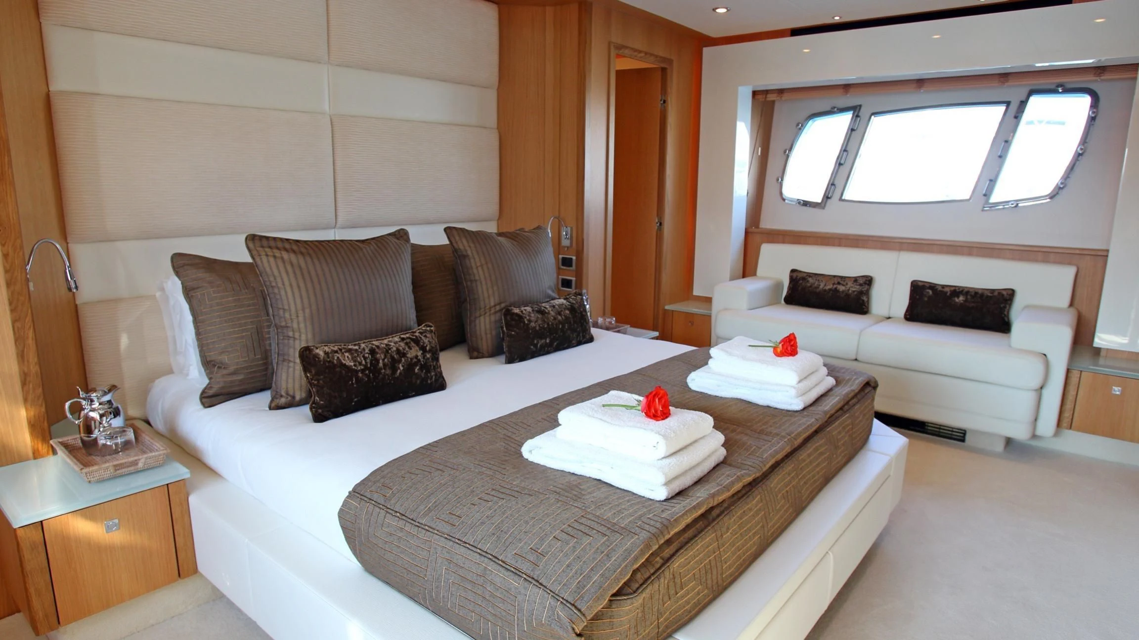 a bed with a white couch and pillows aboard BST SUNRISE Yacht for Sale