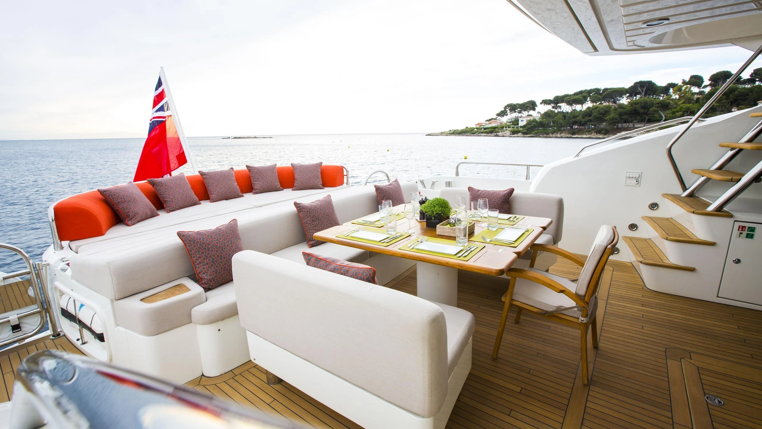 a living room with a large white sofa and a flag on the wall aboard BST SUNRISE Yacht for Sale