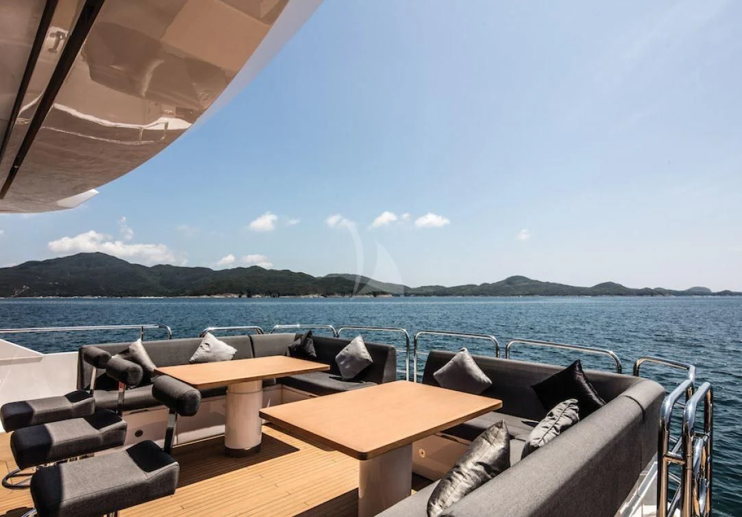a deck with chairs and a body of water in the background aboard OKSANCHIK Yacht for Charter