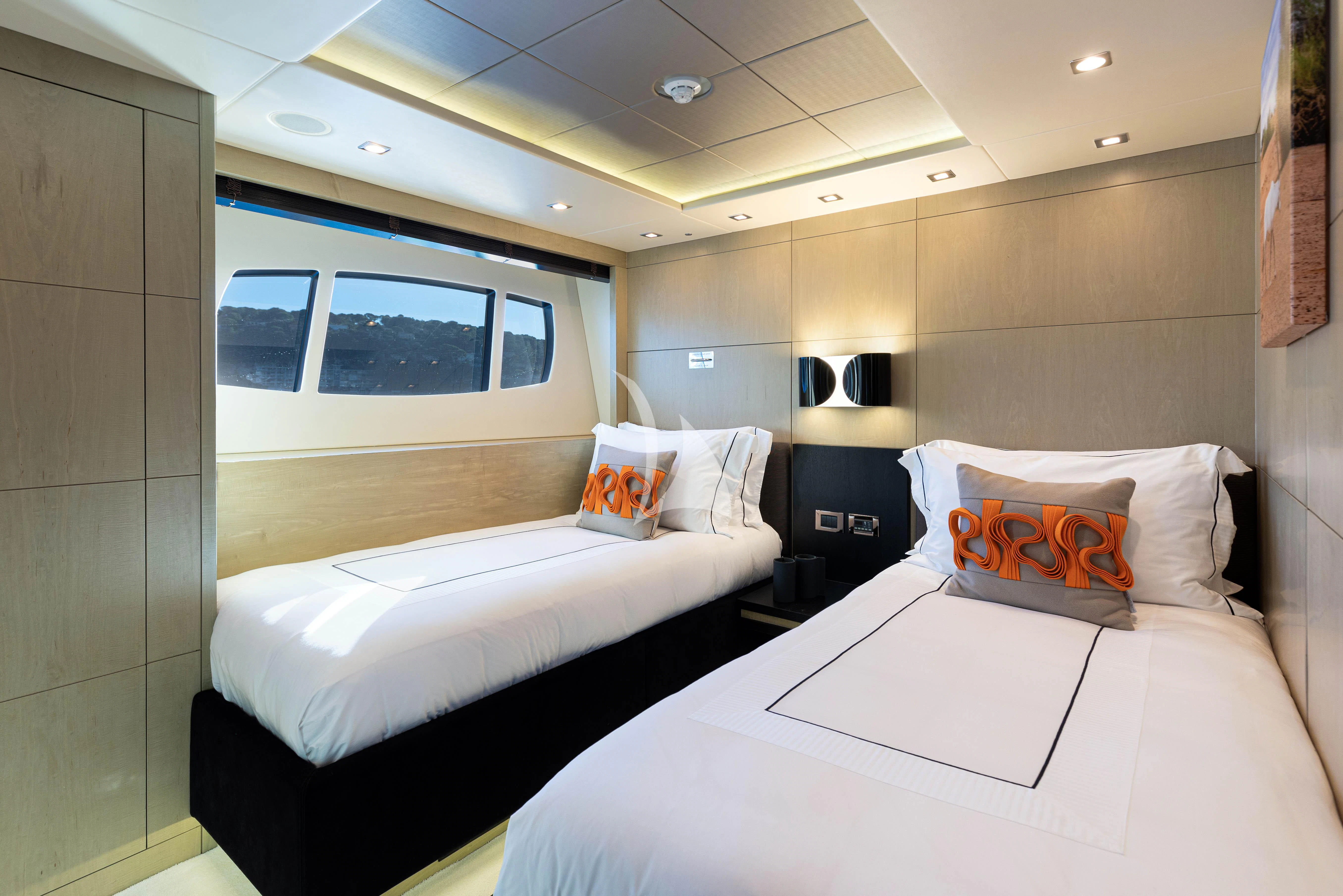 a room with beds and a window aboard OKSANCHIK Yacht for Charter
