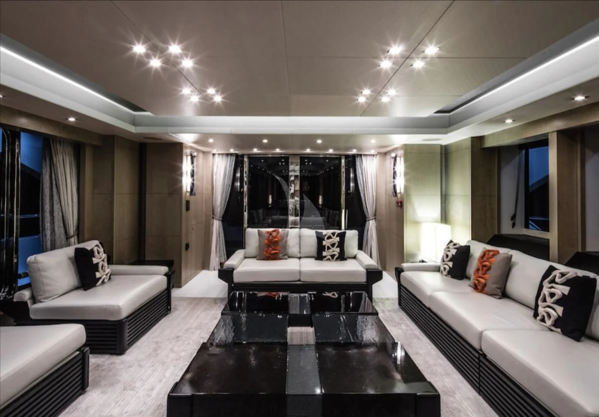 a living room with a large black table and white couches aboard OKSANCHIK Yacht for Charter