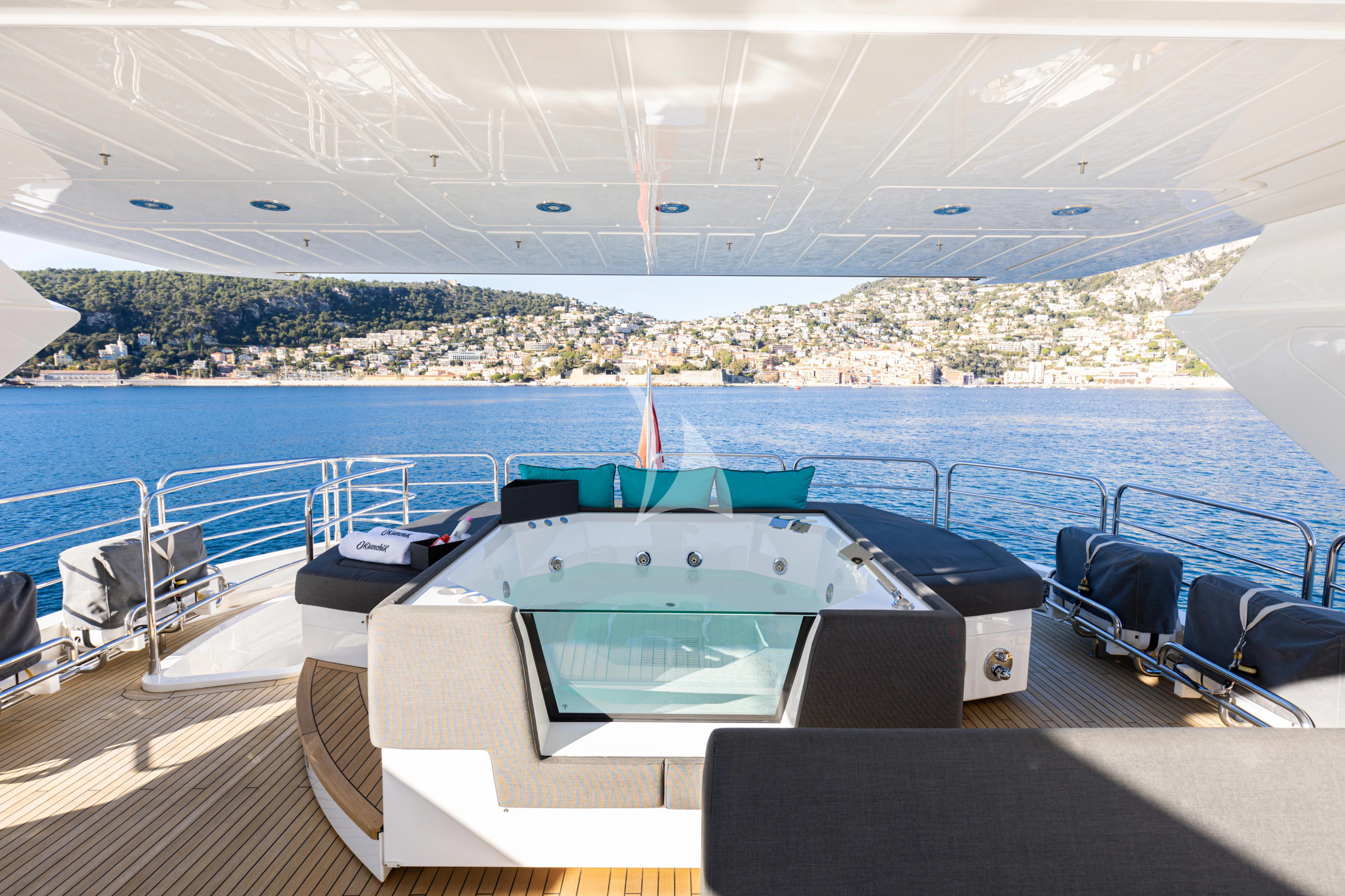 a pool on a deck overlooking a beach aboard OKSANCHIK Yacht for Charter