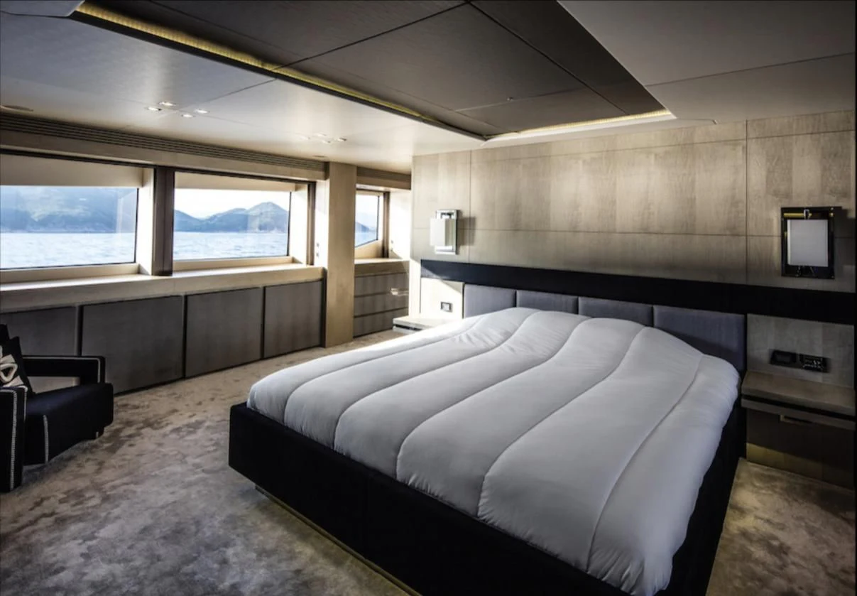 a room with a bed and a chair aboard OKSANCHIK Yacht for Charter