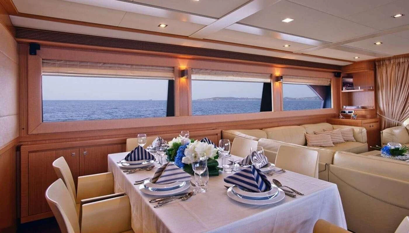 a dining table with a view of the ocean aboard DANA Yacht for Sale