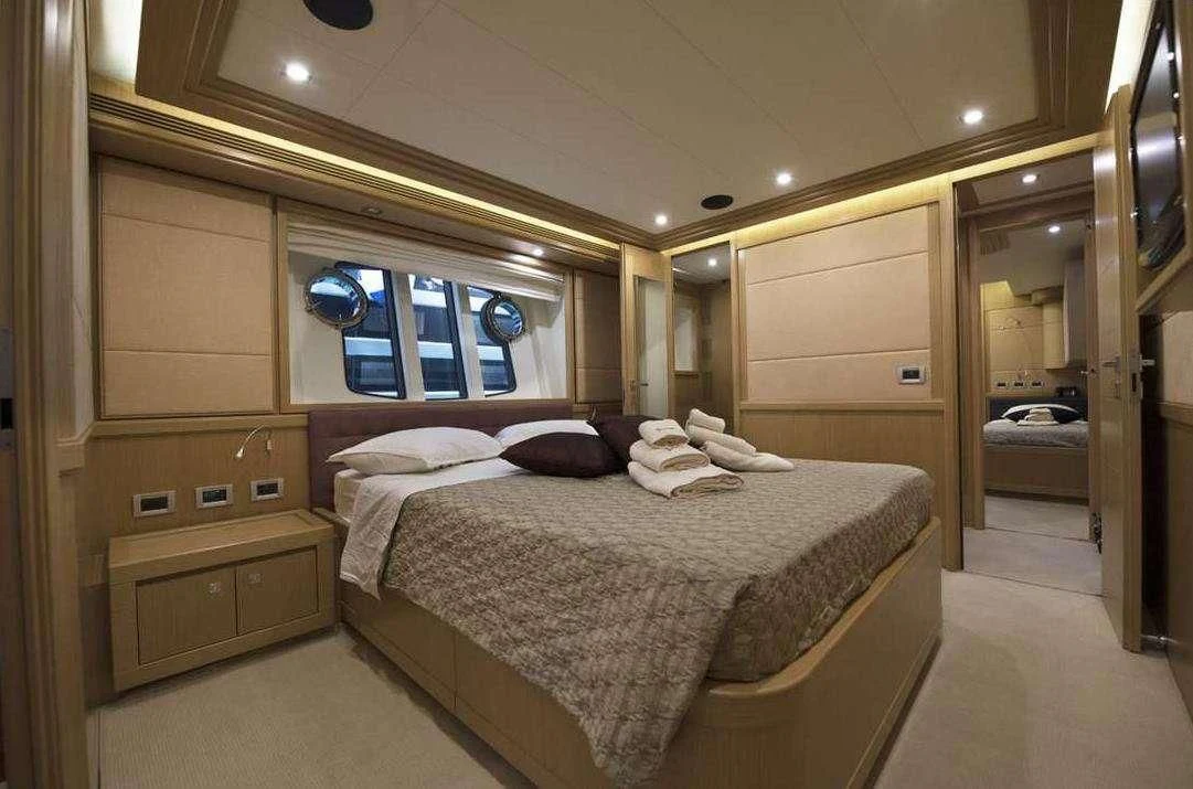 a bedroom with a bed and a mirror aboard DANA Yacht for Sale