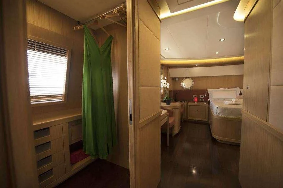a bedroom with a green curtain aboard DANA Yacht for Sale
