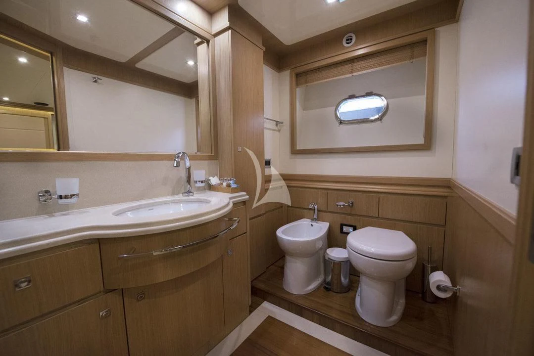 a bathroom with a toilet sink and a mirror aboard DANA Yacht for Sale