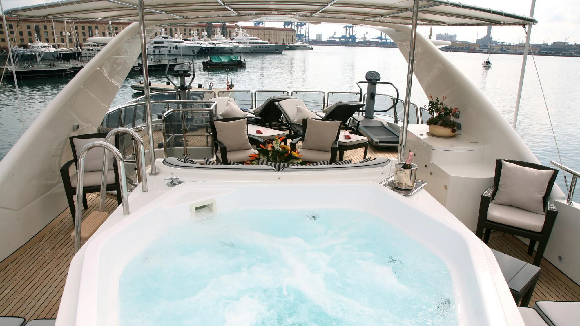 a large white lounge chair next to a pool with a table and chairs aboard SATINE Yacht for Sale