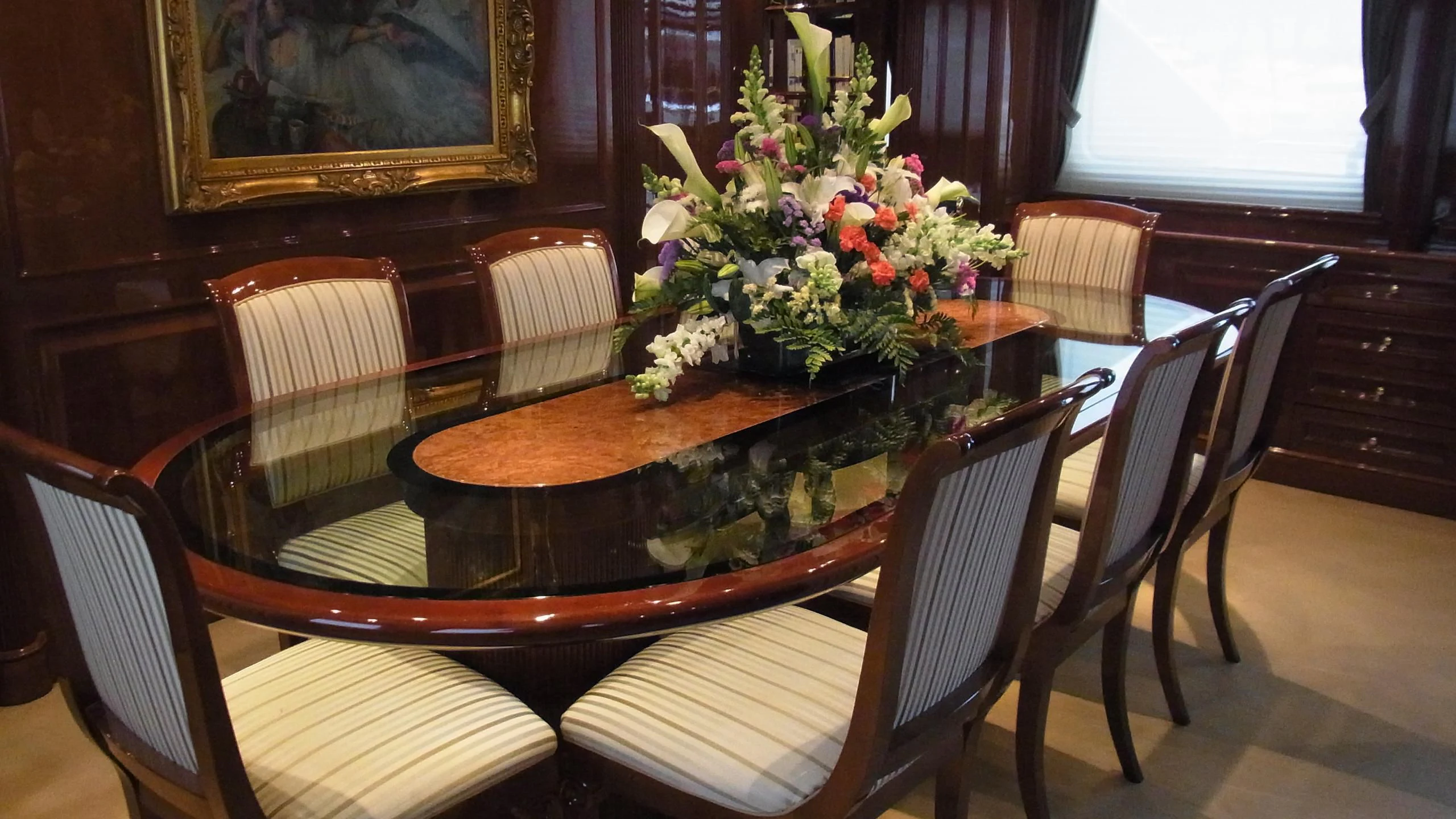 a dining table with chairs and flowers aboard SATINE Yacht for Sale
