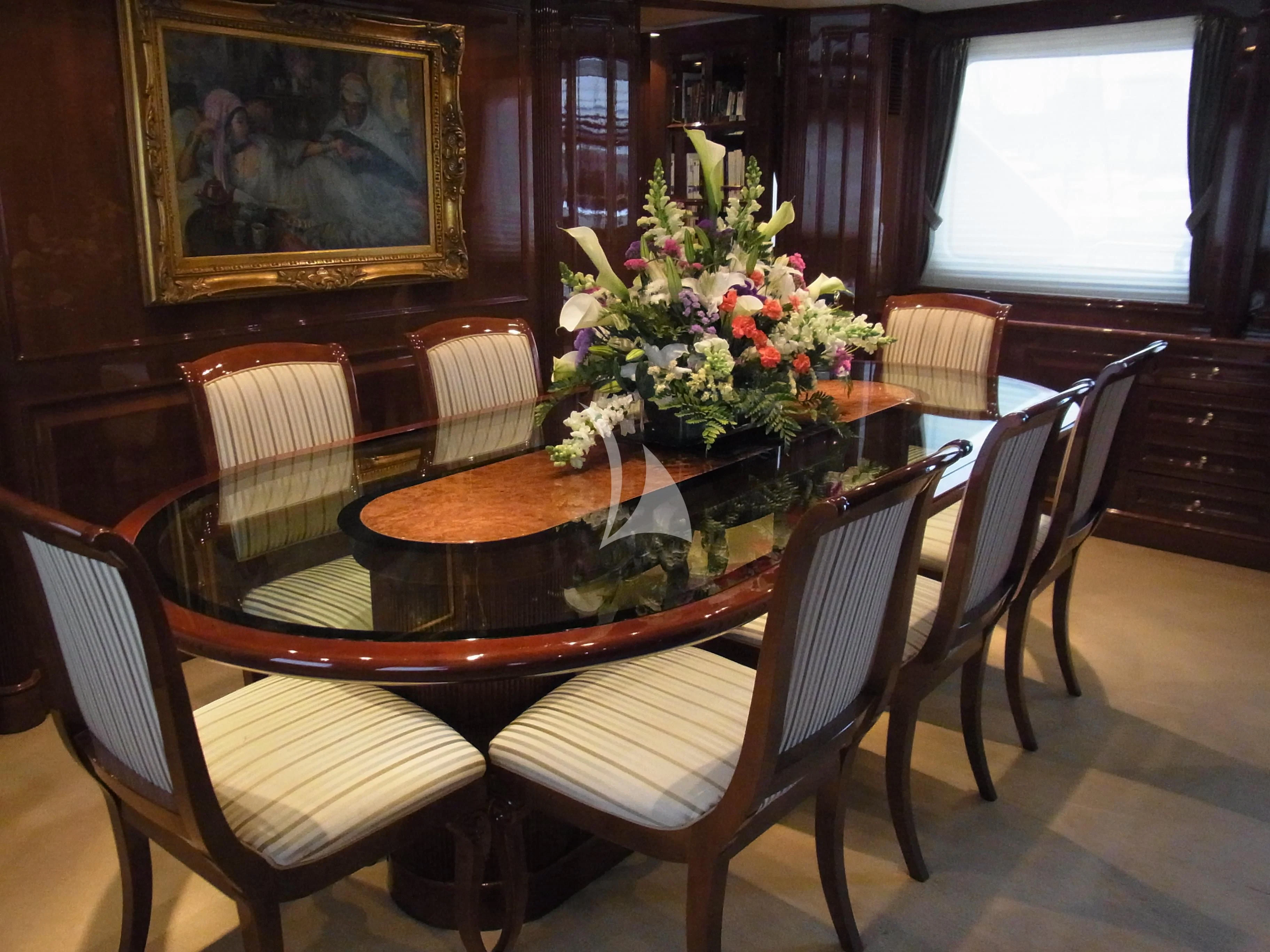 a dining table with chairs and flowers aboard SATINE Yacht for Sale