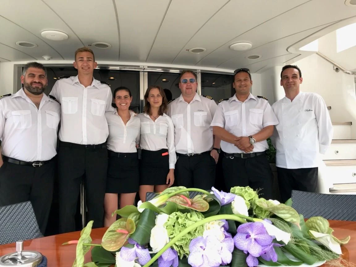 a group of people posing for a photo aboard SATINE Yacht for Sale