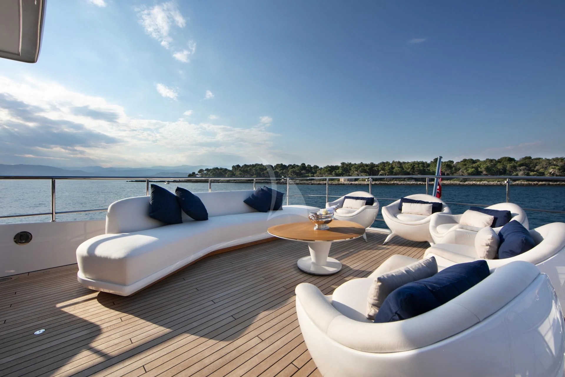 a large white lounge chair on a deck overlooking a large body of water aboard NAZ Yacht for Sale