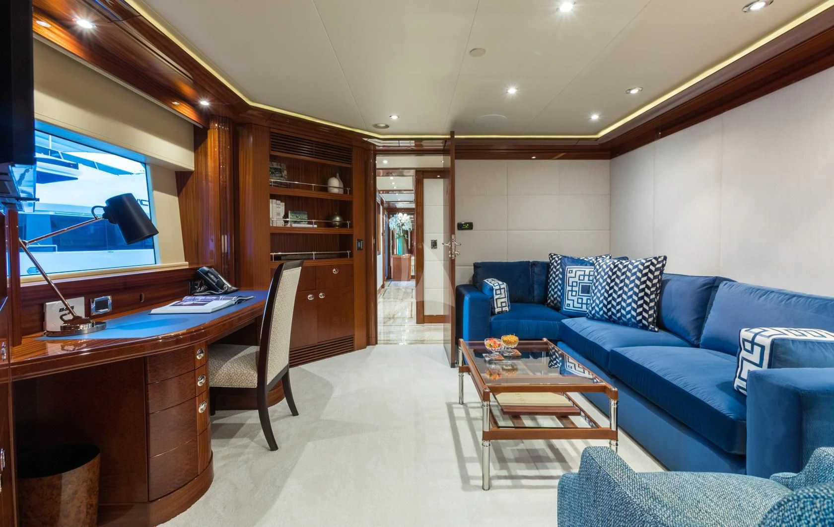 a living room with a blue couch and a television aboard CHASING DAYLIGHT Yacht for Sale