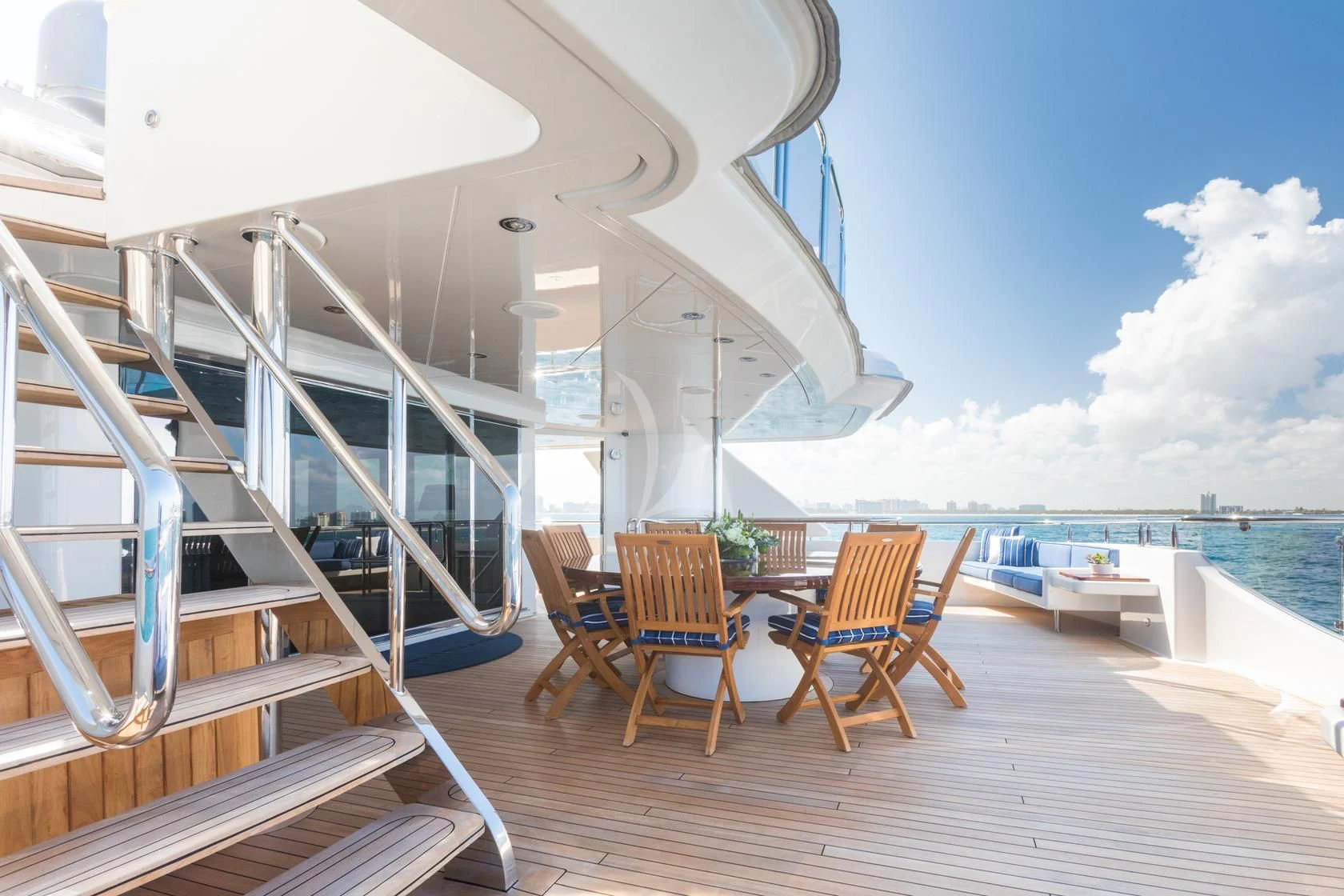 a deck with chairs and a table on it aboard CHASING DAYLIGHT Yacht for Sale