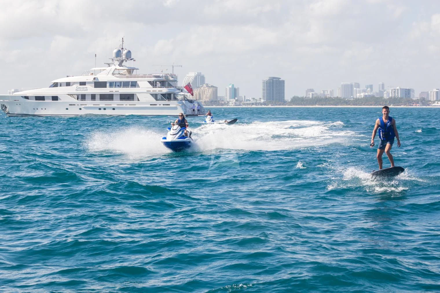 a man and a woman on a jet ski in the ocean aboard CHASING DAYLIGHT Yacht for Sale