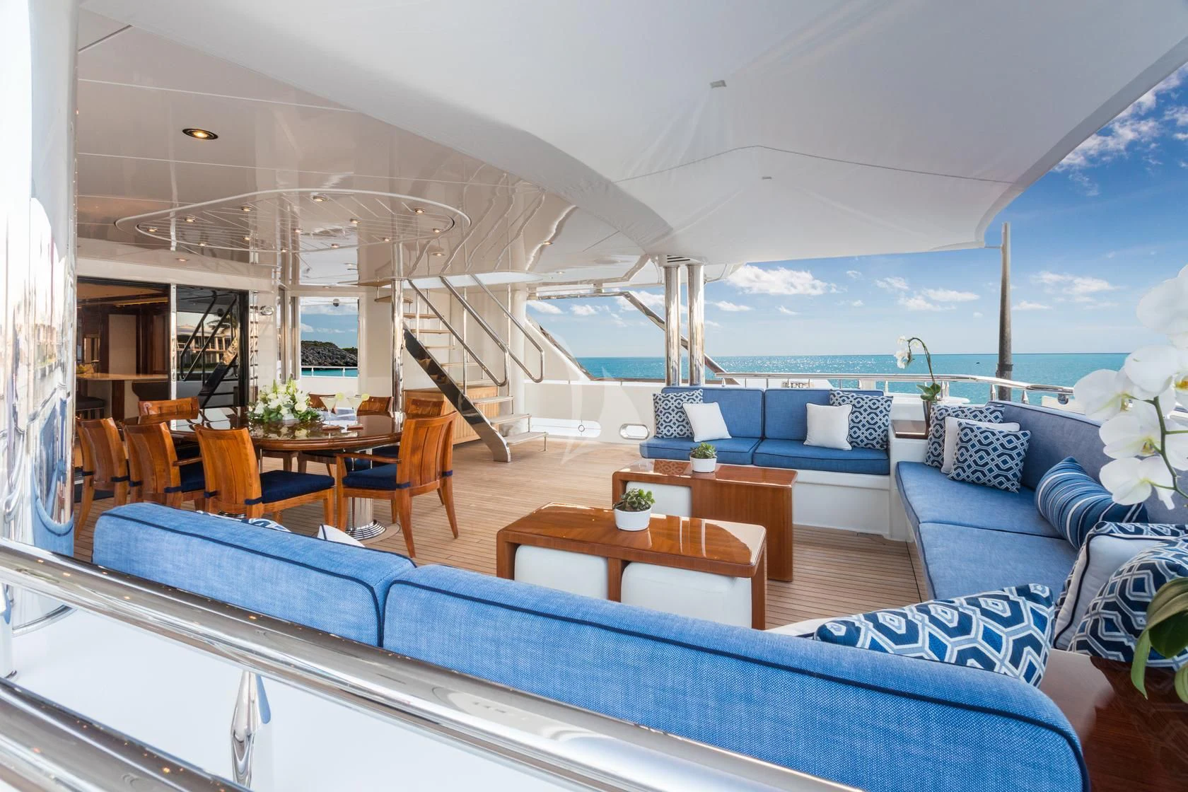 a living room with a large blue couch and a large window aboard CHASING DAYLIGHT Yacht for Sale