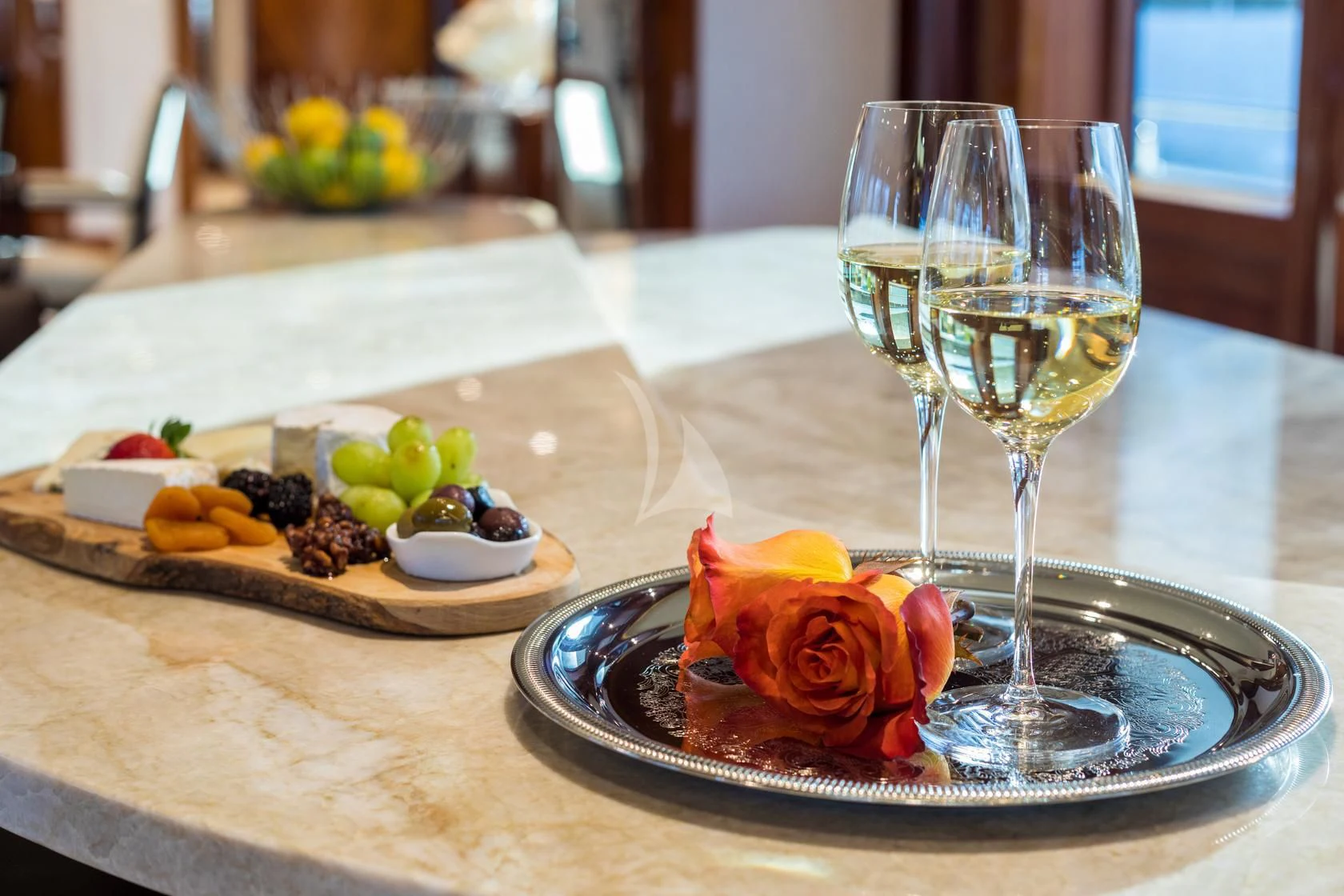 a plate of food and a glass of wine on a table aboard CHASING DAYLIGHT Yacht for Sale