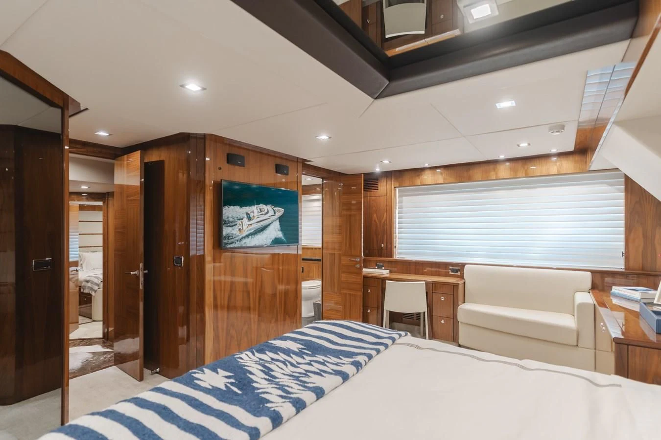 a room with a bed and a desk aboard INDECENT PROPOSAL 4 Yacht for Sale