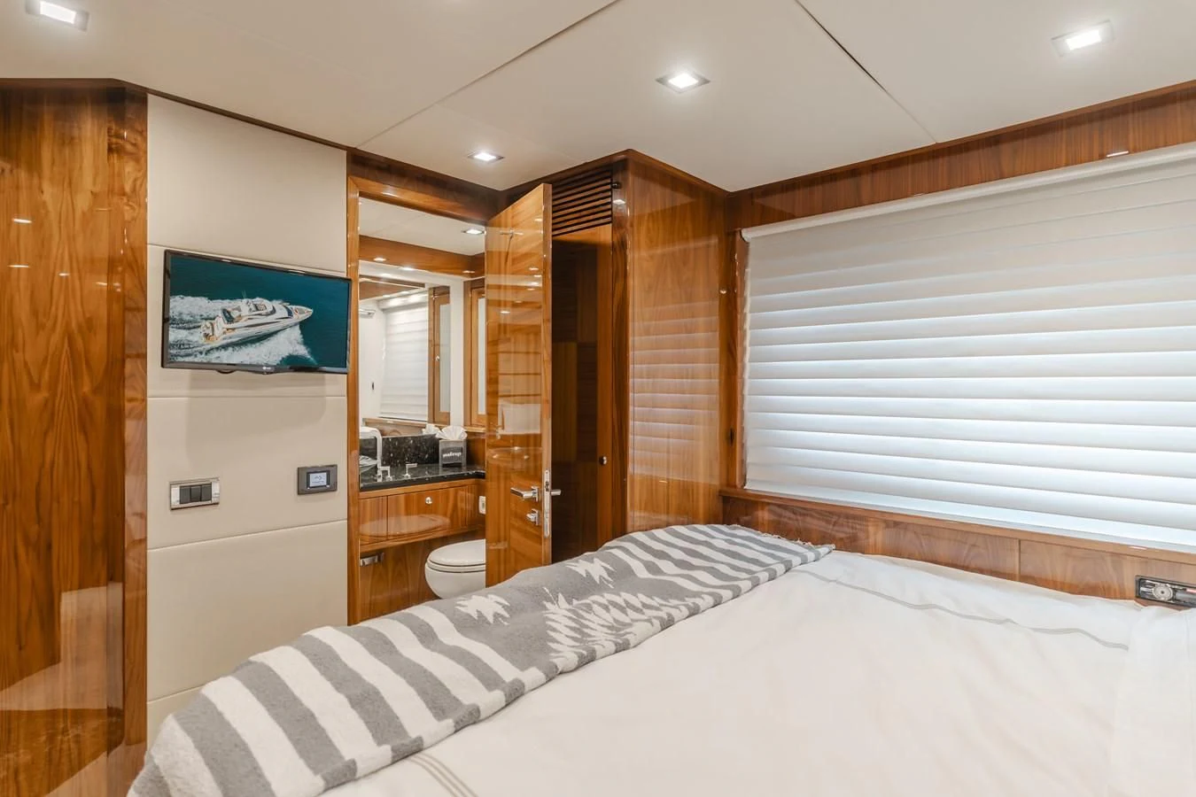 a bedroom with a bed and a wood closet aboard INDECENT PROPOSAL 4 Yacht for Sale
