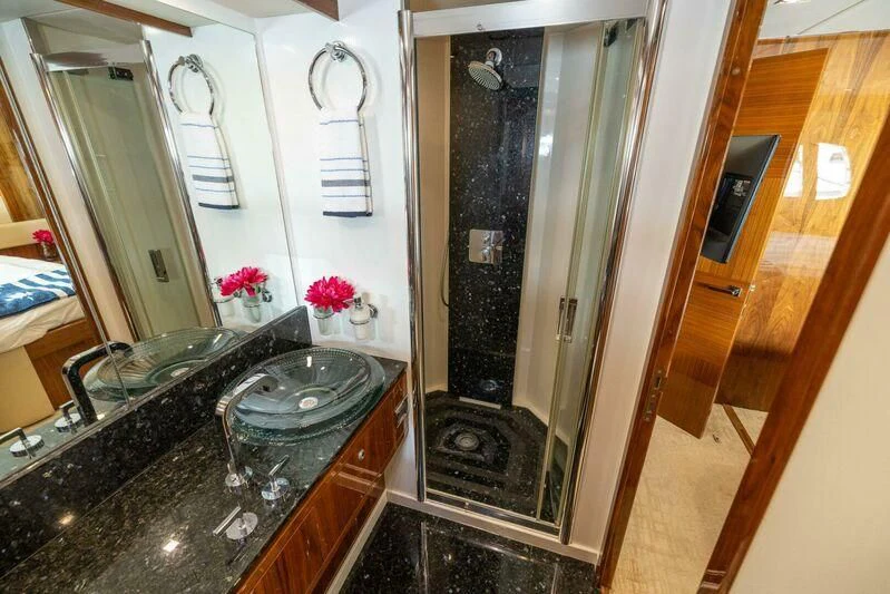 a bathroom with a sink and a mirror aboard INDECENT PROPOSAL 4 Yacht for Sale