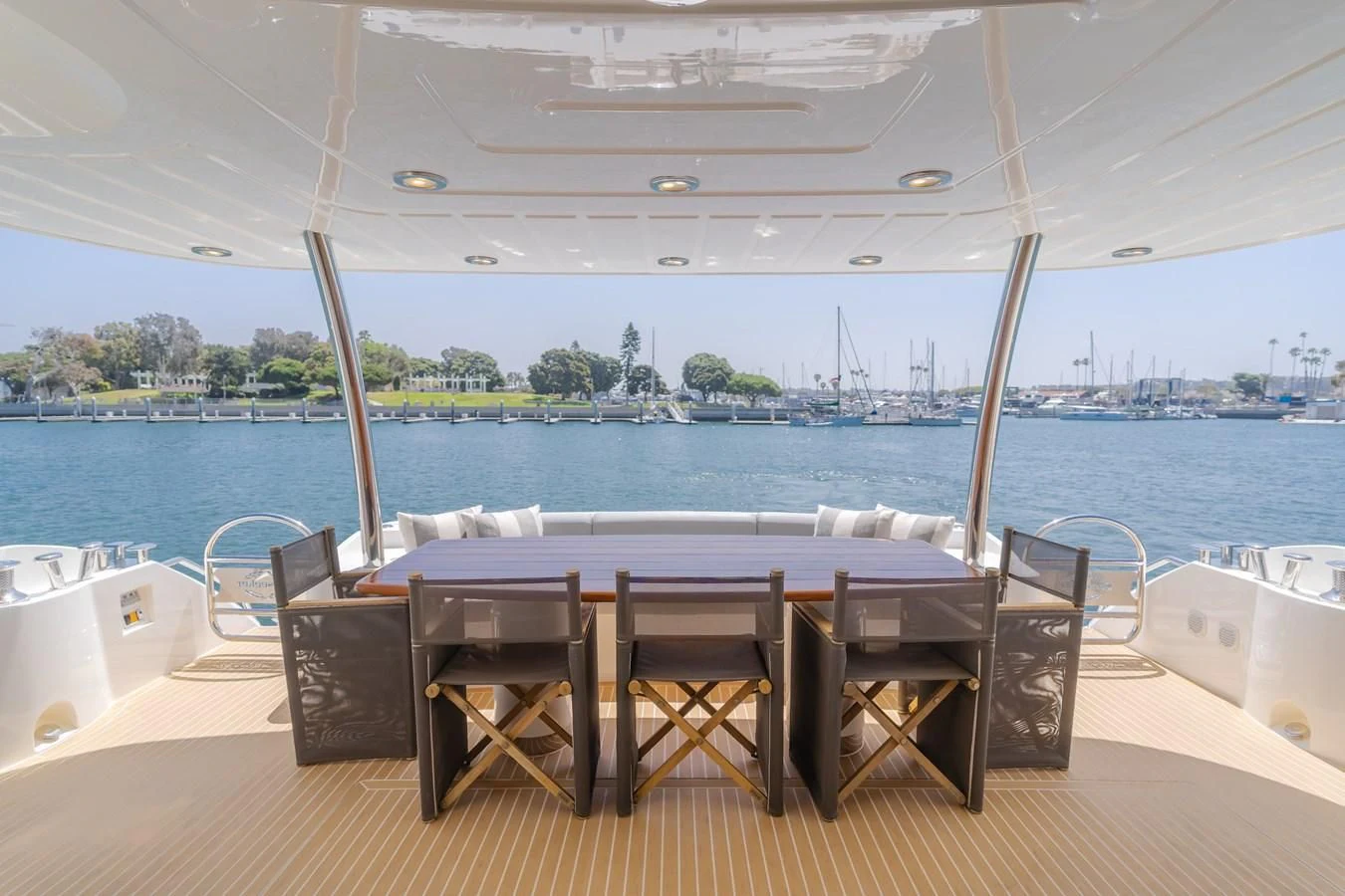 a table and chairs on a deck overlooking a body of water aboard INDECENT PROPOSAL 4 Yacht for Sale