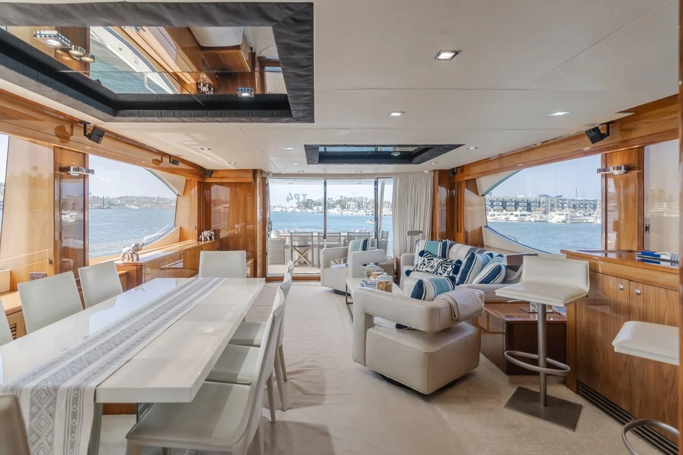 a room with a large window and a table with chairs and a view of the water aboard INDECENT PROPOSAL 4 Yacht for Sale