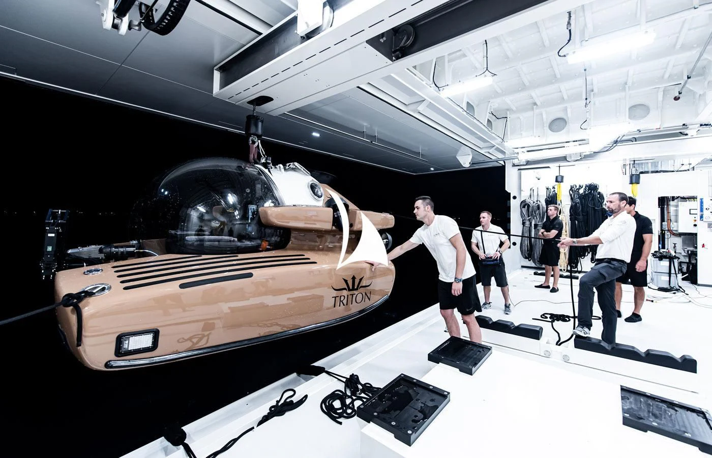 a group of people in a room with a car on a platform aboard LA DATCHA Yacht for Sale