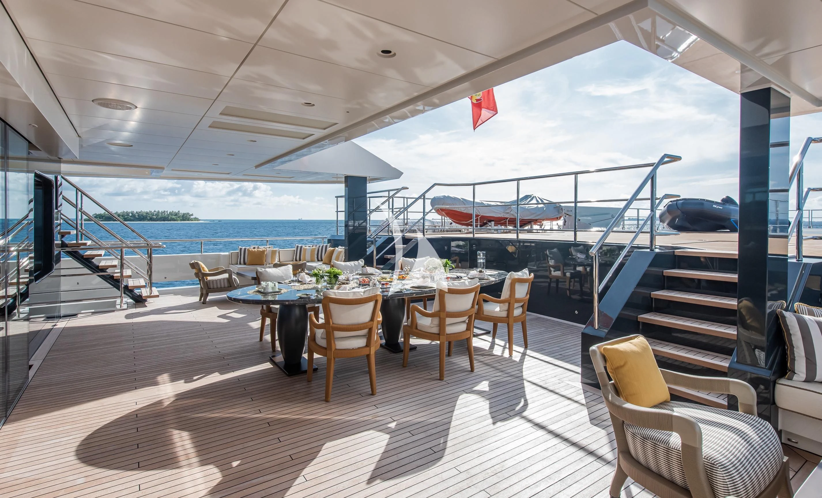 a deck with a table and chairs aboard LA DATCHA Yacht for Sale