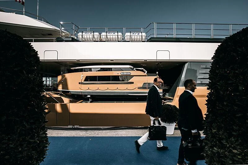 a man and woman walking by a large white building aboard LA DATCHA Yacht for Sale