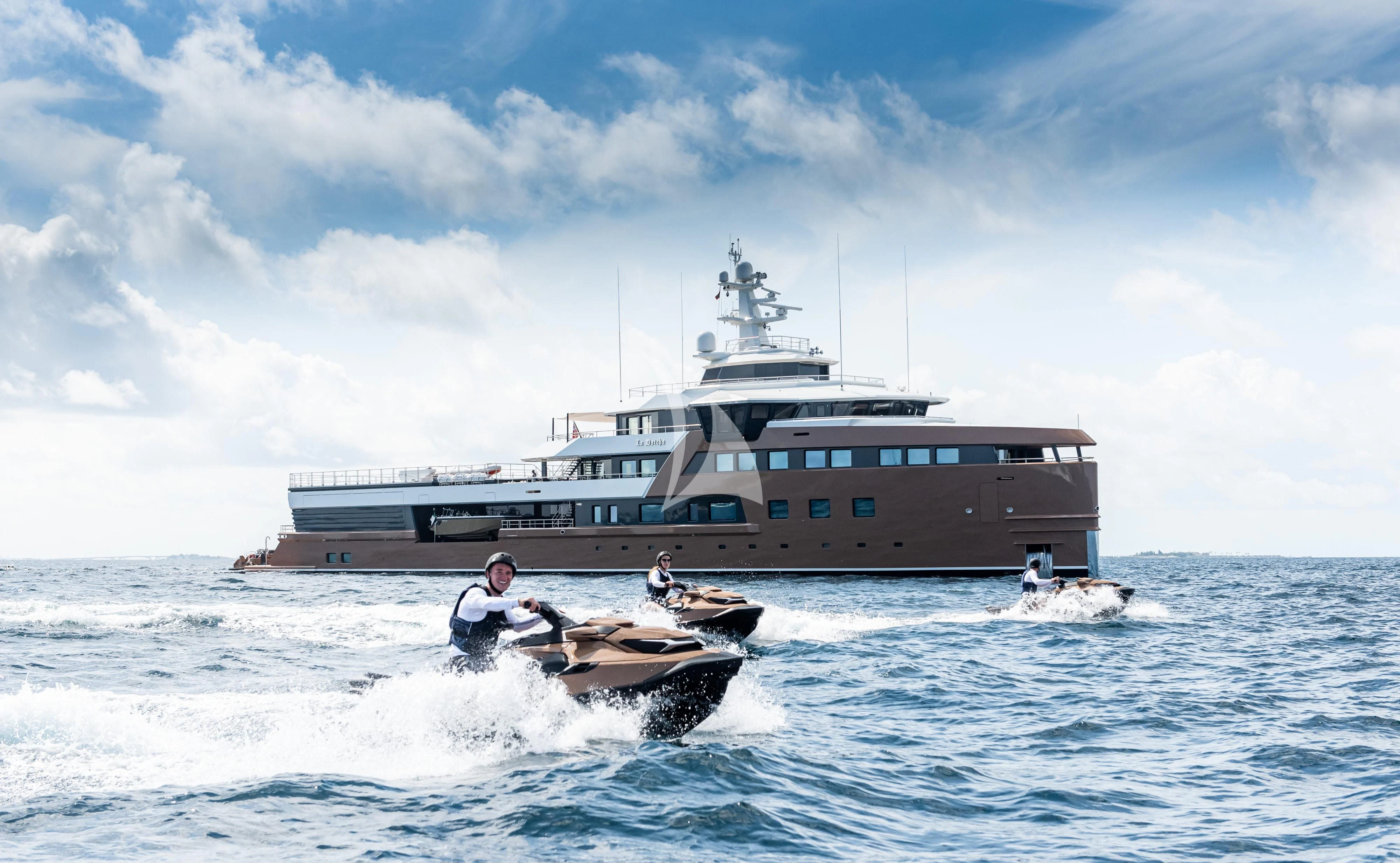 a boat in the water with a large ship in the background aboard LA DATCHA Yacht for Sale