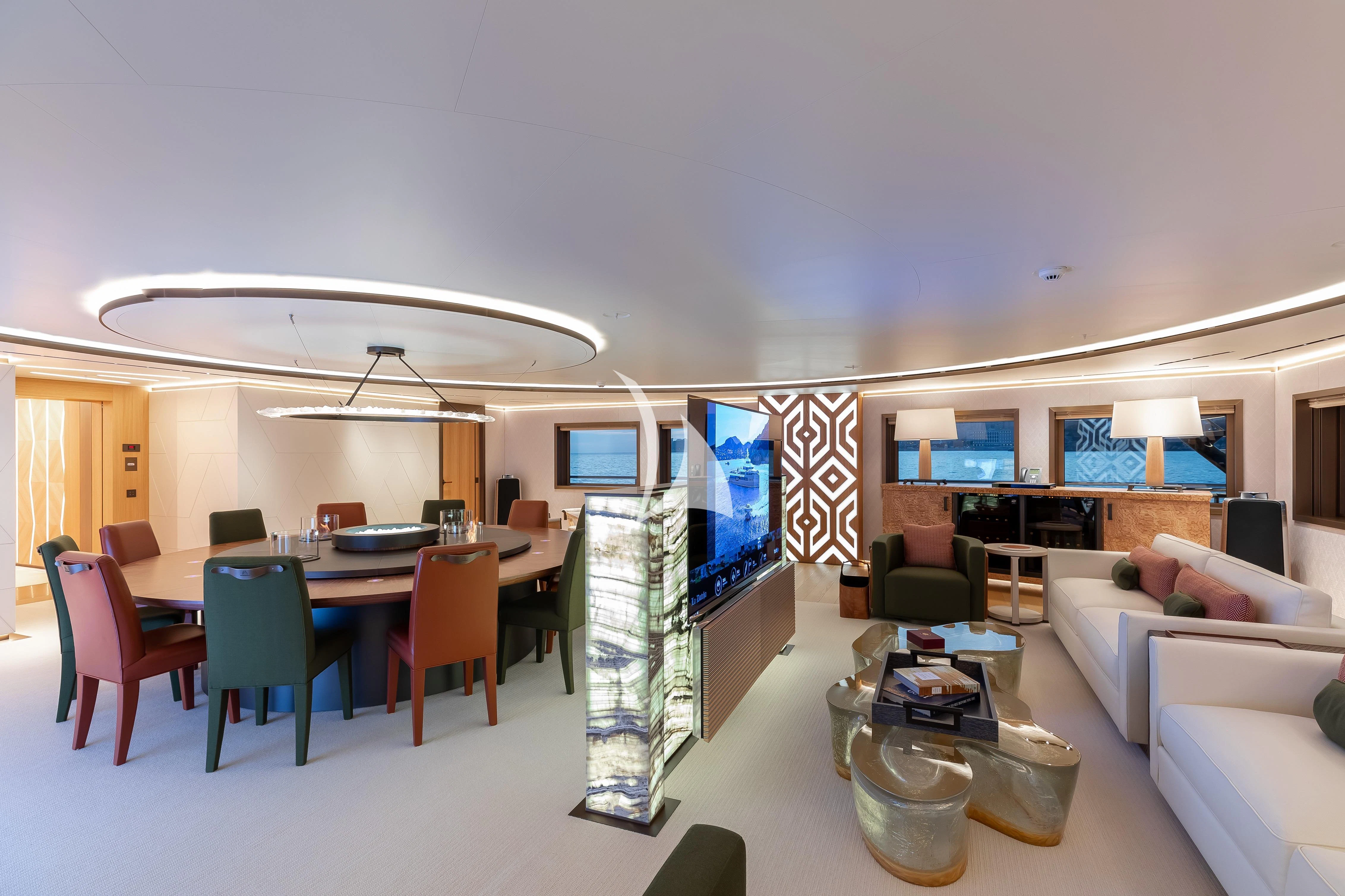 a room with a table chairs and a television aboard LA DATCHA Yacht for Sale