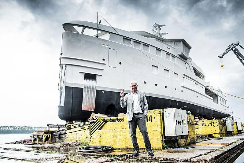 a man standing in front of a large ship aboard LA DATCHA Yacht for Sale