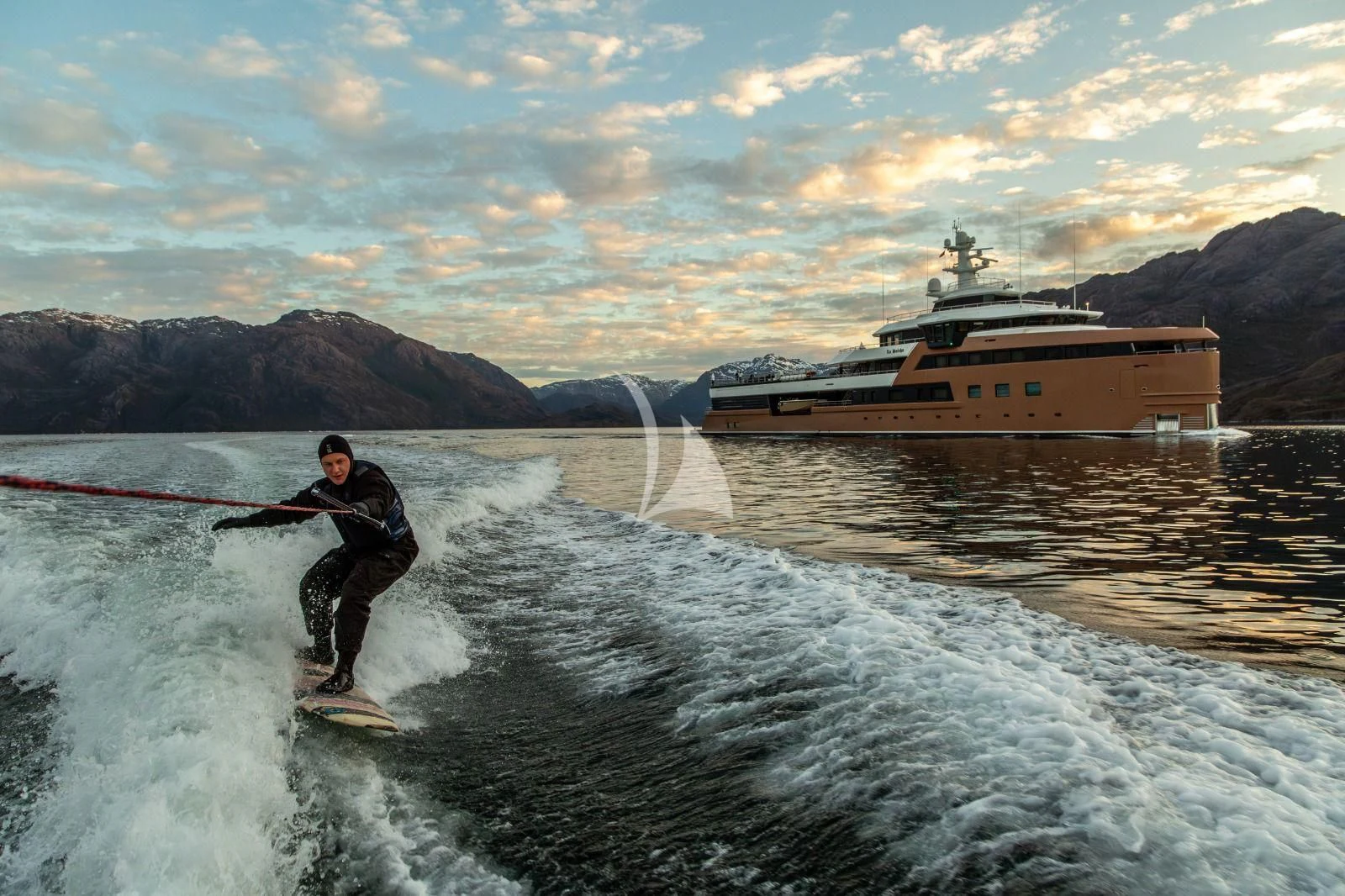 a man surfing on the waves aboard LA DATCHA Yacht for Sale