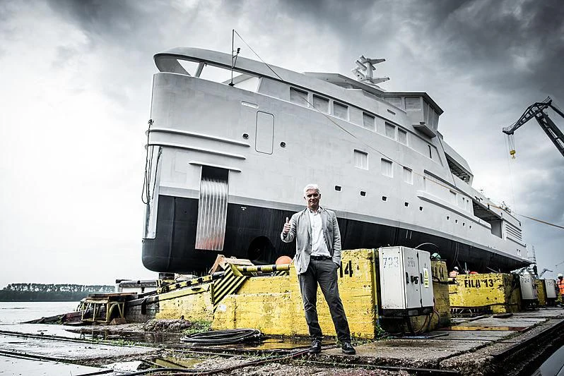 a man standing in front of a damaged building aboard LA DATCHA Yacht for Sale