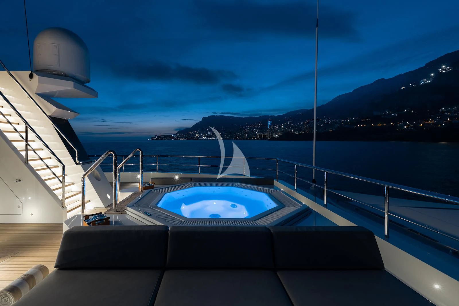 a pool on a deck overlooking a city at night aboard LA DATCHA Yacht for Sale