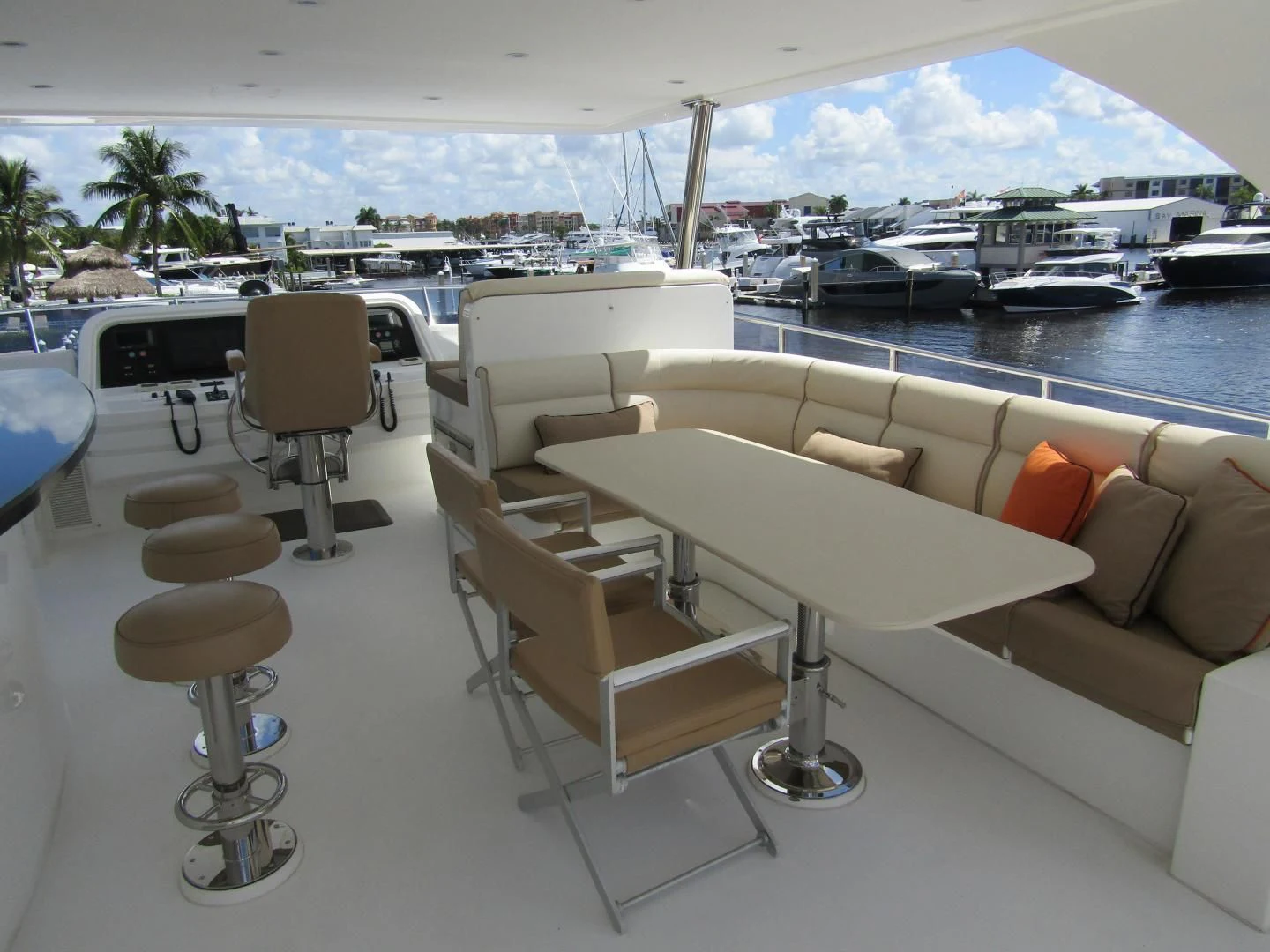 a room with a couch and a table with chairs and a body of water in the background aboard LADY C II Yacht for Sale