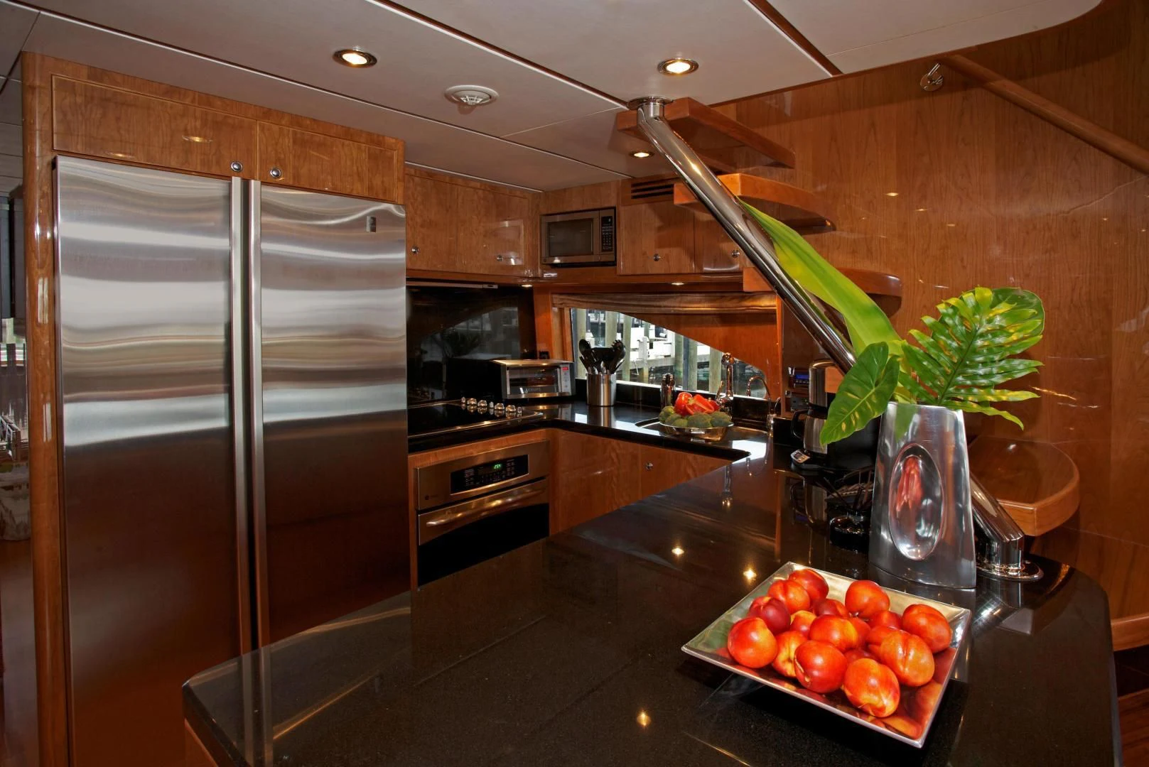 a kitchen with a large refrigerator and a bowl of tomatoes aboard LADY C II Yacht for Sale