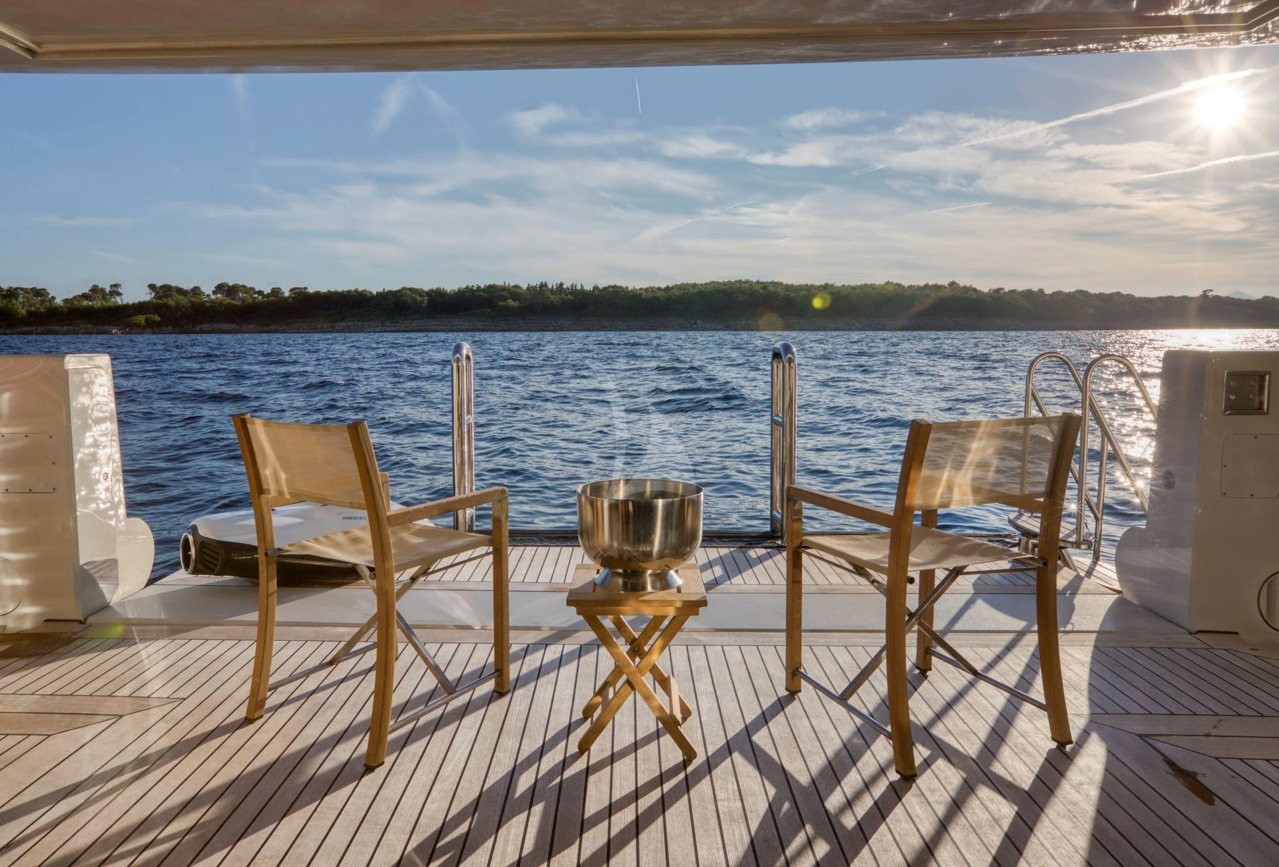 a table and chairs on a deck overlooking a lake aboard MARAYA Yacht for Sale